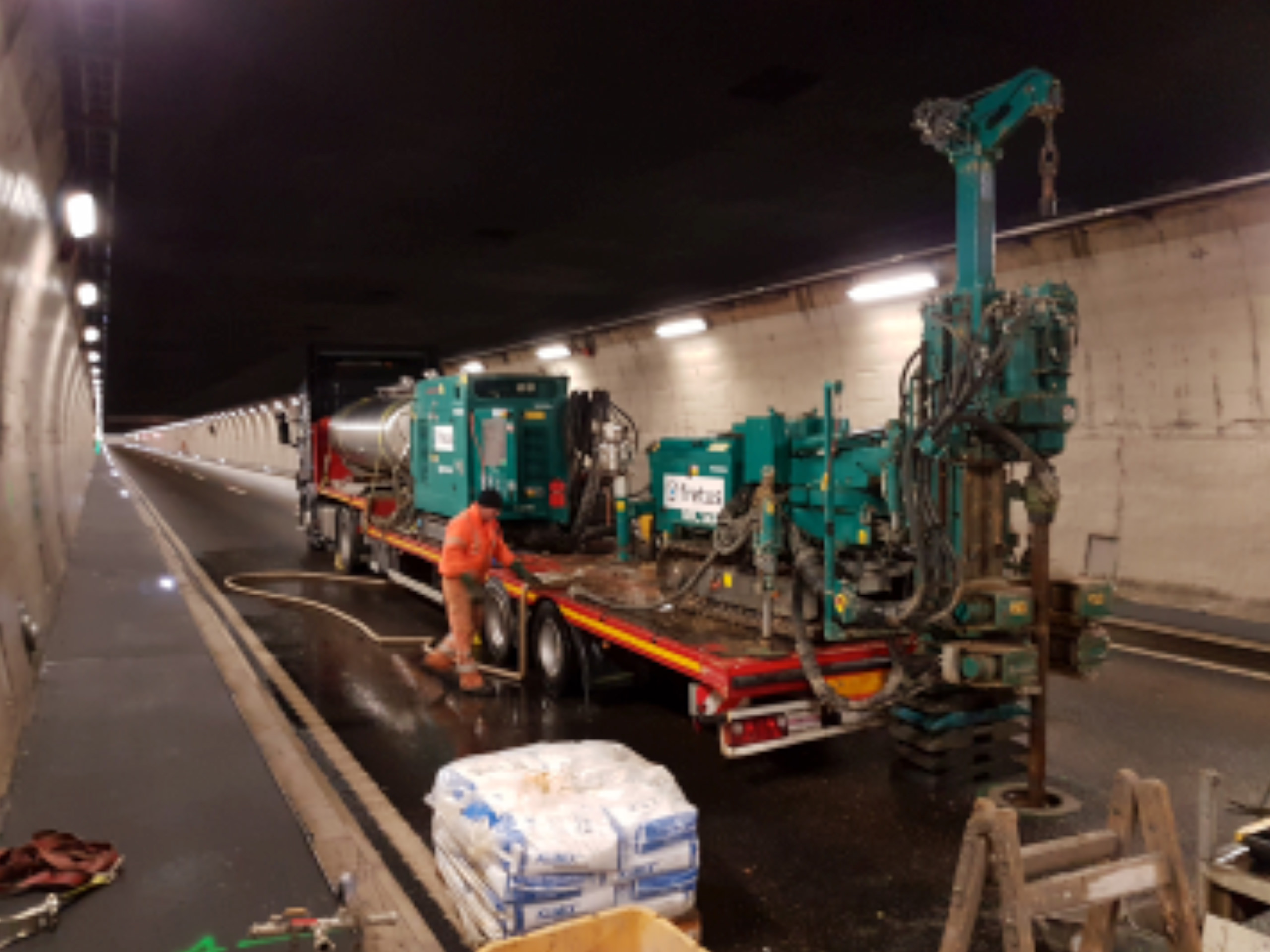 Bauarbeiter und LKW mit Bohrmaschine in Strassentunnel