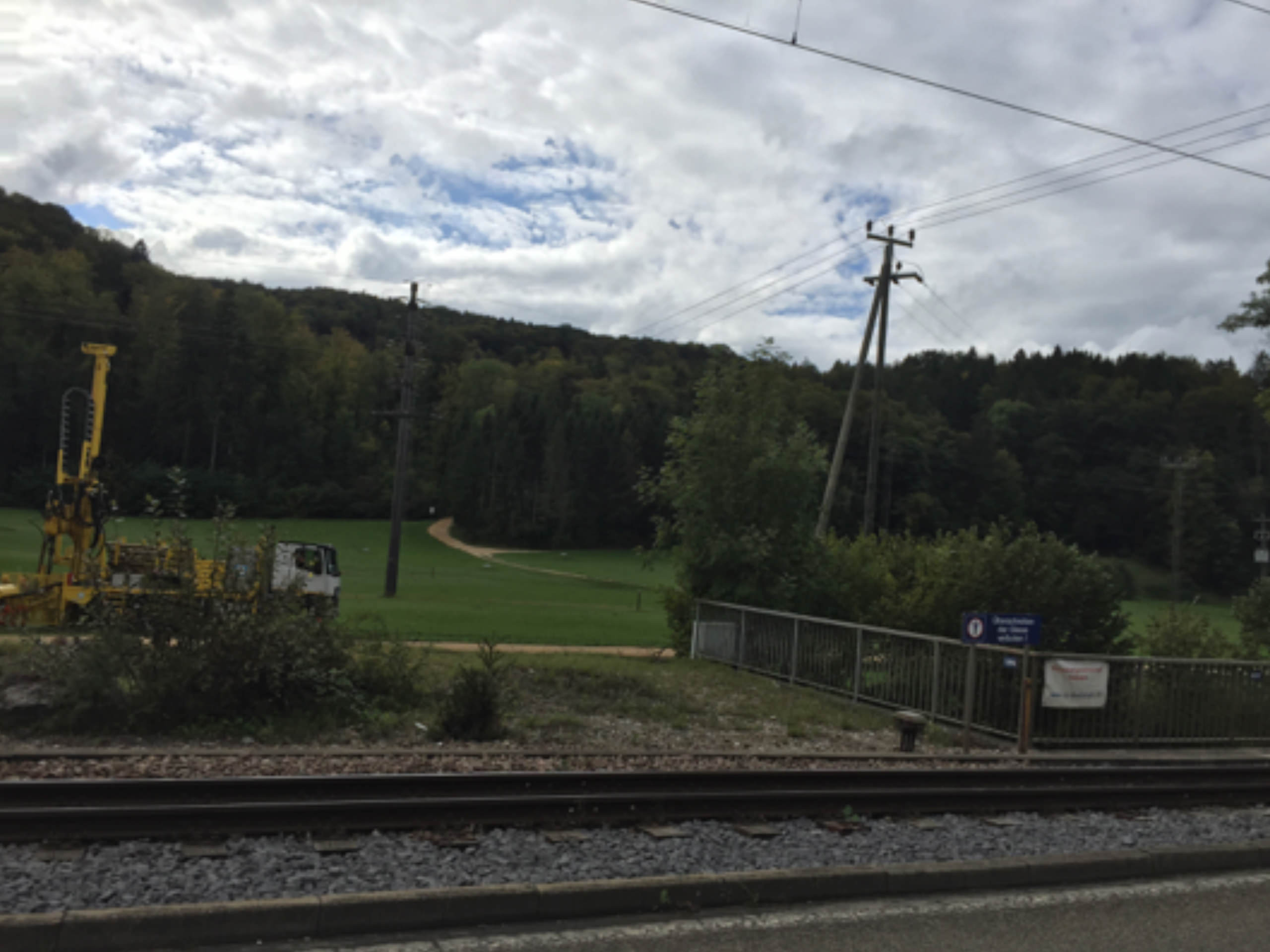 Bohrmaschine an Bahngleisen mit Wald im Hintergrund